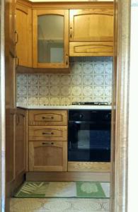 a kitchen with wooden cabinets and a stove at Casa Farfalla in Cannobio