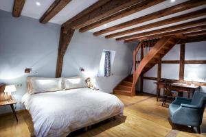 a bedroom with a white bed and a blue chair at Hôtel & Spa Le Bouclier D'or in Strasbourg