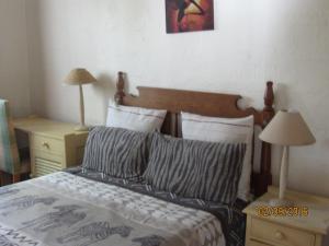 a bedroom with a bed with two night stands and two lamps at Toad Tree Cabins in Sodwana Bay +60 photos