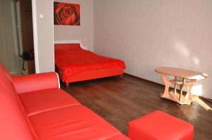 ザポリージャにあるApartment Universitetskaya 54のリビングルーム(赤いソファ、テーブル付)