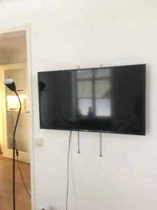 a flat screen tv hanging on a white wall at Zemfira AB, Visby Innerstad in Visby