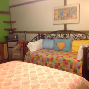 a bedroom with a bed with colorful pillows on it at The Main Street Hotel in Yazoo City