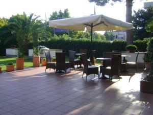 un patio con mesa, sillas y sombrilla en Residence Aurora, en Albenga