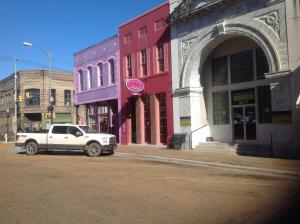 a white truck parked on the side of a city street at The Main Street Hotel in Yazoo City