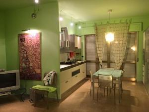 a kitchen with a table and chairs in a room at Appartamento verde in Marina di Gioiosa Ionica