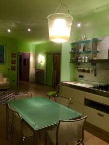 a green kitchen with a table and chairs at Appartamento verde in Marina di Gioiosa Ionica