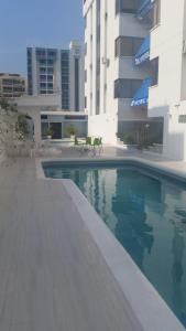 a swimming pool in front of a building at Hotel Yuldama Rodadero Inn in Santa Marta
