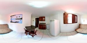eine Küche mit weißen Fliesenböden und einem Kühlschrank in der Unterkunft Residencial Ponta Negra Flat in Natal