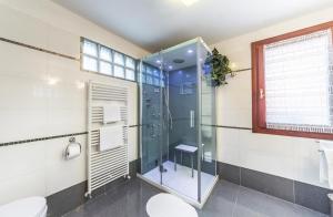 y baño con ducha de cristal y aseo. en Ca' Delfina Holiday Home, en Venecia
