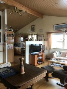 a living room with a coffee table and a tv at Eiði Farmhouse in Grundarfjordur
