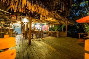 a restaurant with tables and chairs and an umbrella at Hotel Casa Perico in Río Dulce