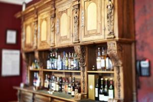 a wooden bar with lots of bottles of alcohol at Hôtel & Spa Le Bouclier D'or in Strasbourg