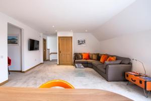 a living room with a gray couch and orange pillows at Tower Ridge Courtyard in Fort William