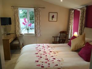 um quarto com uma cama com pétalas de rosa em THE FIRS B&B &TEA ROOM em Summer Bridge