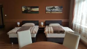 Cette chambre comprend deux lits, une table et des chaises. dans l'établissement Penzion 324, à Štoky