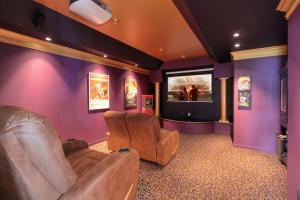 a movie room with two chairs and a flat screen tv at Cheers B&B in West Kelowna
