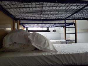 1 cama con sábanas blancas y almohadas en una habitación en Rock n Bowl, en Bristol