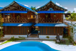 a house with a swimming pool in front of it at Hotel Utüane in Leticia