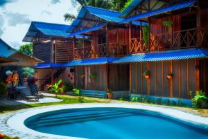 a house with a swimming pool in front of it at Hotel Utüane in Leticia