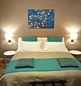 una camera da letto con un grande letto e un dipinto sul muro di Le Suite dei Due Mari cucinino privato a Taranto
