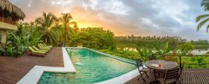 - une piscine avec des chaises et une table sur une terrasse dans l'établissement Villa Playa Tayrona, Los Naranjos, à Los Naranjos