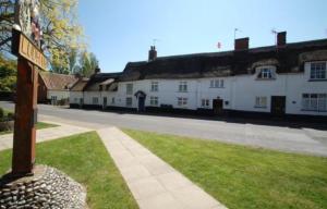 a street sign in front of a white building at Bakers Cottage Ludham - Norfolk Broads in Ludham