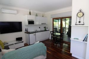 a kitchen and living room with a couch and a table at Westering Cottage in Wandin North