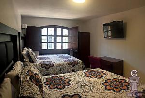 1 dormitorio con 2 camas y ventana en Hotel Casa Cantera, en León