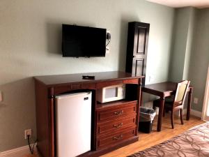 a room with a desk with a tv and a refrigerator at Calimesa Inn in Calimesa