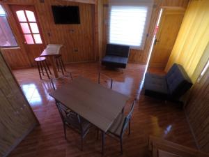 a room with a table and chairs and a television at Rio Lingue in Valdivia +24 photos