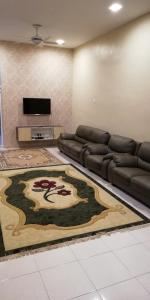 ein Wohnzimmer mit einem Sofa und einem Teppich in der Unterkunft Hazim Homestay Changlun Pakej Esklusif in Changlun