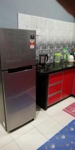 uma cozinha com um frigorífico de aço inoxidável e um balcão em Hazim Homestay Changlun Pakej Esklusif em Changlun