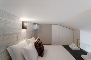 a bedroom with a white bed with white pillows at Vila Madre Deus II in Lisbon