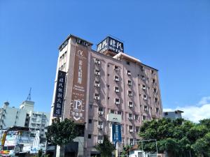 un edificio alto con letreros a un lado. en Unique Hotel, en Hualien City