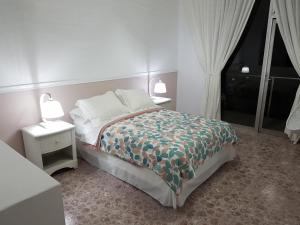 a bedroom with a bed with two night stands and two lamps at Posada Greco in Mexico City