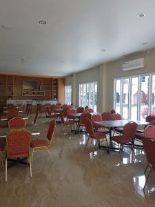 a large room with tables and chairs and windows at Hotel Grand Sigma in Lahat