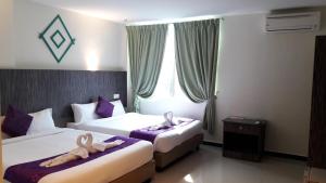a hotel room with two beds and a window at Salsa Resort Langkawi By Casa Loma in Pantai Cenang