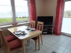 a dining room with a table and chairs and a television at Ferienwohnung Sauerlandblick in Korbach