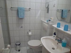 a bathroom with a toilet and a sink at Ferienwohnung Sauerlandblick in Korbach +54 photos