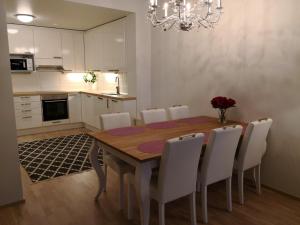 uma cozinha e sala de jantar com uma mesa de madeira e cadeiras em Charming Pine View Apartment em Vantaa