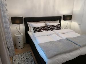 a bedroom with a large bed with two lamps at Charming Pine View Apartment in Vantaa