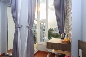 een kamer met paarse gordijnen en een bureau voor een raam bij Home Peace Home - District 1 in Ho Chi Minh-stad