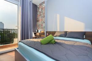 - une chambre dotée d'un lit avec un oreiller vert dans l'établissement Home Peace Home - District 1, à Hô-Chi-Minh-Ville