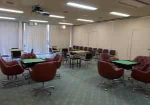 una sala de conferencias con mesas y sillas. en Hotel New Momiji, en Nasushiobara