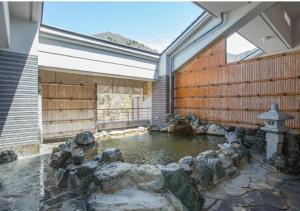una piscina d'acqua in un edificio con rocce di Hotel New Momiji a Nasushiobara