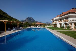 a large swimming pool in front of a building at Yonca Hotel in Adrasan