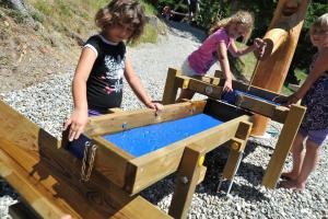 two girls playing in a wooden box with water at Gasserhütte in Innerkrems