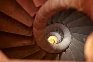 a spiral staircase with a light at the top at Hôtel & Spa Le Bouclier D'or in Strasbourg