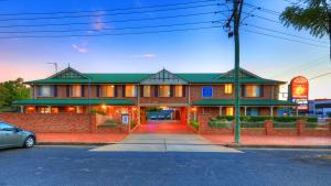 un edificio con un coche aparcado delante de él en Endeavour Court Motor Inn, en Dubbo