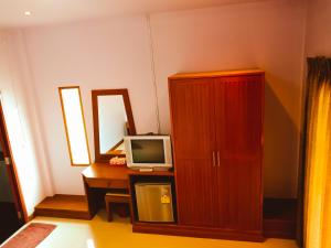 Ban Tai Resort في بان تاي: غرفة بها مكتب مع تلفزيون وخزانة